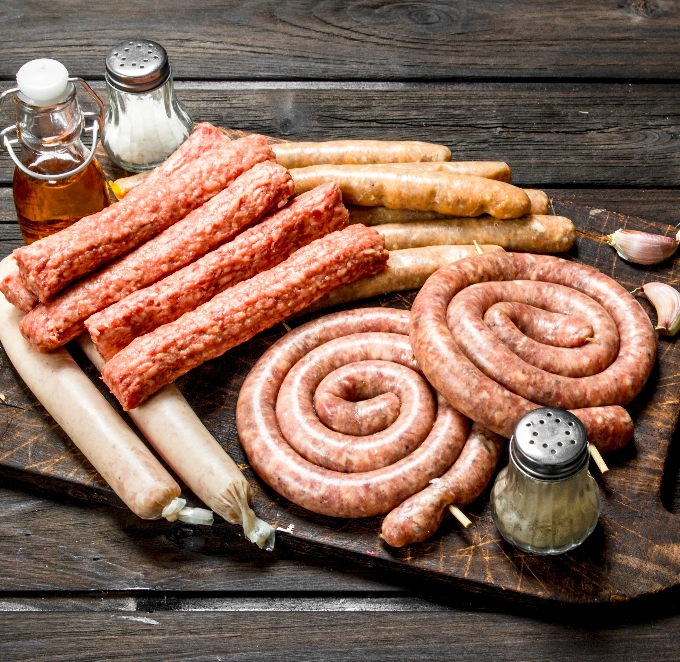 different-kinds-raw-sausages-wooden-board-with-spices-wooden-surface@2x